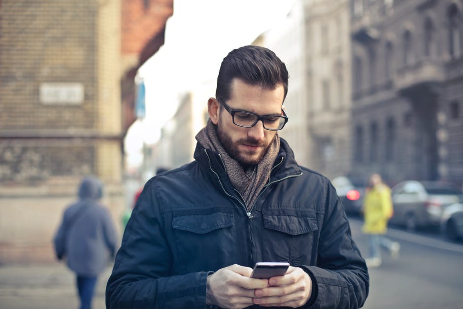 Stock photo of a young man holding his smart phone.