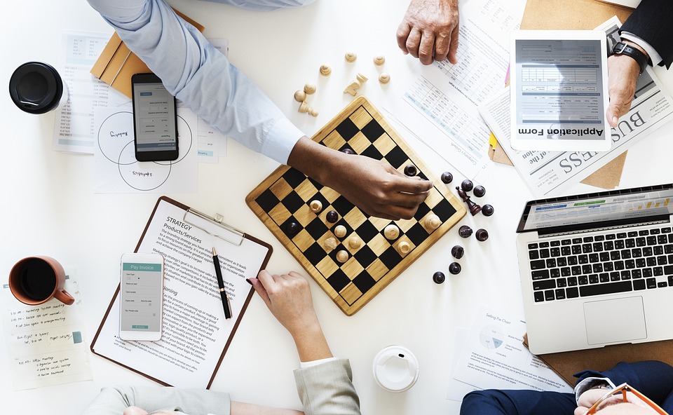 Coworkers playing chess stock photo.